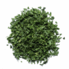 Pile of finely chopped green dried herbs on a white background.