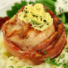 Chicken wrapped in bacon with herb butter on mashed potatoes, green beans, cheese, cranberry.