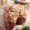 Baked dome-shaped dessert with almonds and powdered sugar in decorative molds on a cloth.