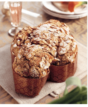 Baked dome-shaped dessert with almonds and powdered sugar in decorative molds on a cloth.