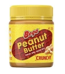 Yellow jar of Bega Peanut Butter, crunchy, with peanuts and text "Never Oily, Never Dry".