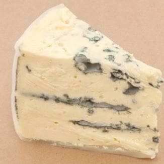 Wedge of blue cheese with creamy color and blue veining, soft and crumbly texture.