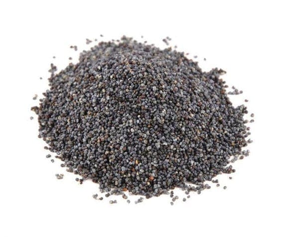 A mound of small, round, blue-grey poppy seeds on a flat surface with a smooth texture.