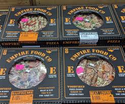 Boxed woodfired pizzas from Empire Food Co. displayed with variety labels and brand details.