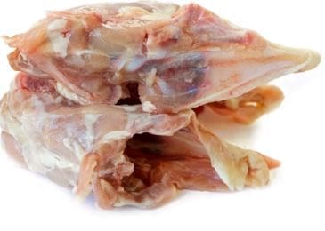 Pile of chicken carcasses with bones and tissue on a white background.