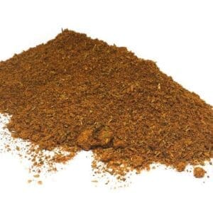 Pile of coarse ground brown spices on a white background with visible particles.