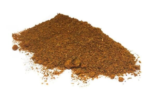 Pile of coarse ground brown spices on a white background with visible particles.