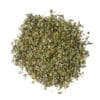 Dried, crushed green leaves on a white background, used as seasoning or herb in cooking.