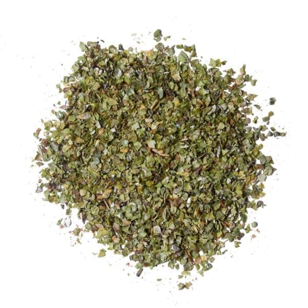 Dried, crushed green leaves on a white background, used as seasoning or herb in cooking.