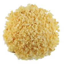 Finely chopped garlic pile; yellowish-white, uneven texture, used in cooking.