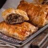 Golden brown puff pastries with savory mushroom filling on a decorative plate.