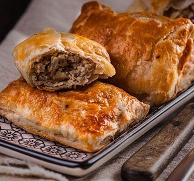 Golden brown puff pastries with savory mushroom filling on a decorative plate.