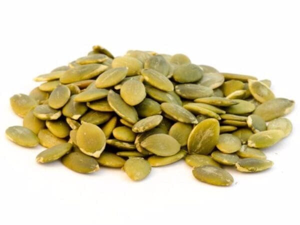 Close-up of green pumpkin seeds (pepitas) on a white background, flat and glossy.