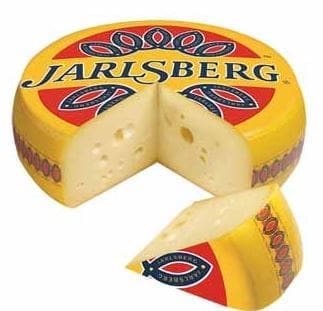 Jarlsberg cheese wheel with yellow-red wrapping and wedge cut, showing pale holes.