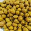 Green olives with pits, shiny from marination, displayed in a pile.