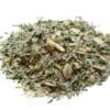 Close-up of mixed dried herbs and spices with green leaves on a white background.