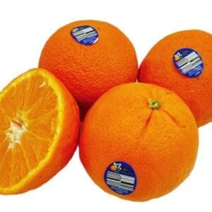 Four ripe oranges, one cut in half, with stickers showing labels and barcodes.