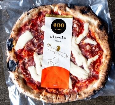Packaged Diavola pizza with salami, cheese, charred crust, "400 Gradi" brand packaging.