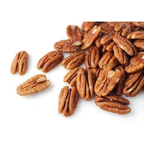 Pecan nuts scattered on white background, showing brown shells with grooves and glossy finish.