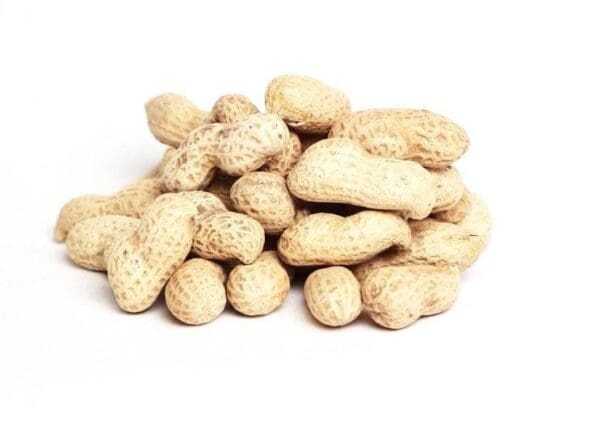 Pile of unshelled peanuts with textured beige shells on a white background.