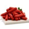 Pile of red cocktail sausages on a light tray with parsley.