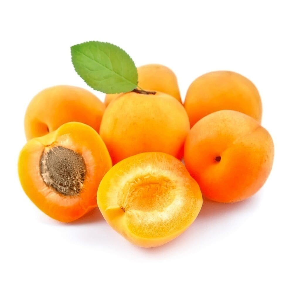 Ripe apricots on white background, some halved with pits, one with a green leaf.