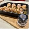 Tray of roasted chicken drumsticks on board with Smokehaus seasoning jar in the foreground.