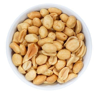 Bowl of shelled, roasted peanuts on a white background.