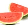 Whole watermelon and slices on white surface, green exterior, red interior with seeds.