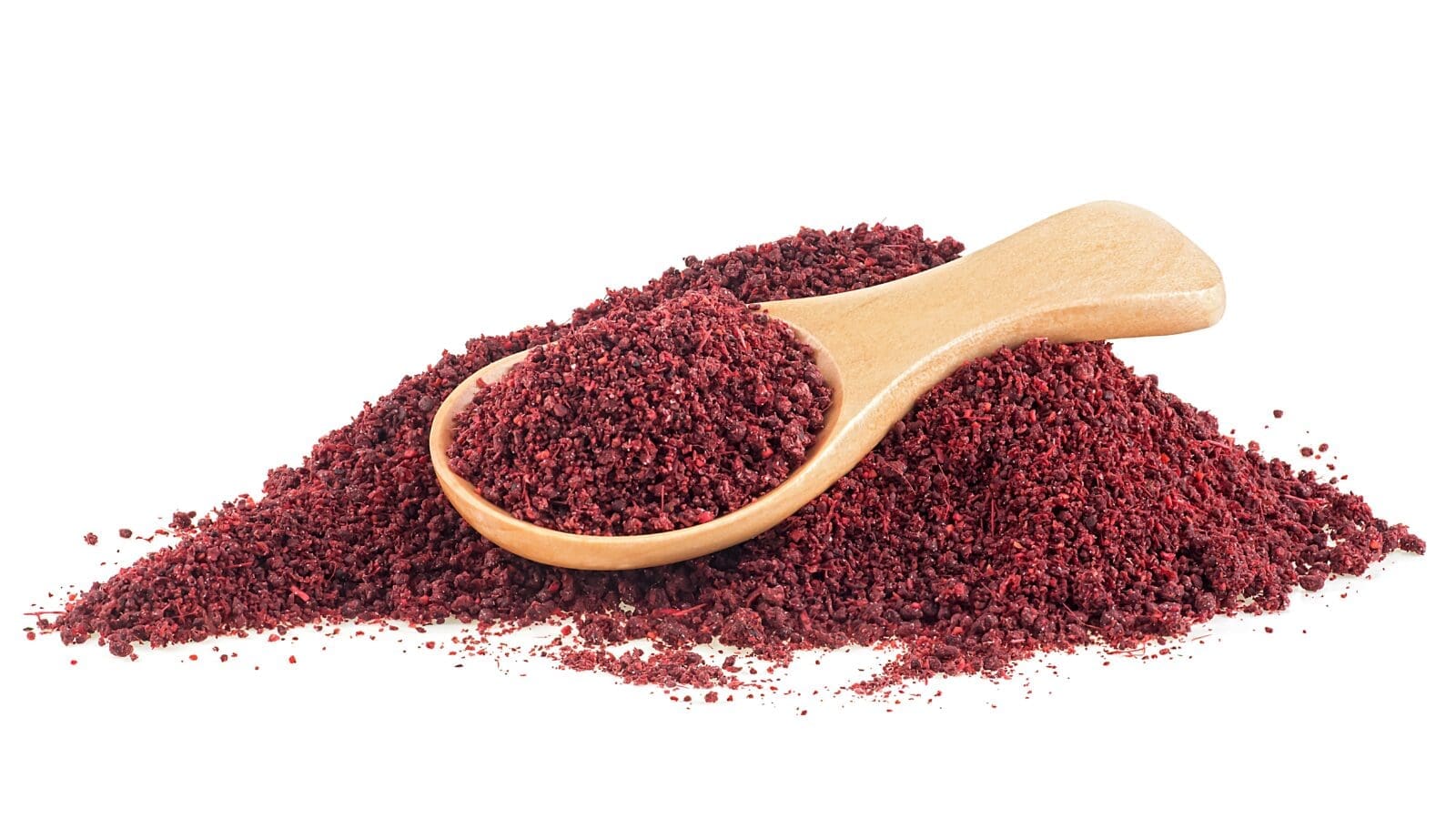 Wooden spoon with red spice on a white surface.