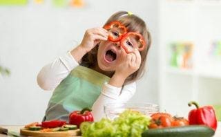 A kid playing with perfectly cut radishes.