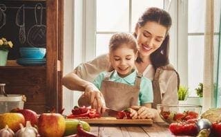 Mom teaching her daughter how to cut radish the right way