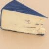 Slice of cheese with smooth interior and blue wax coating on a light surface.