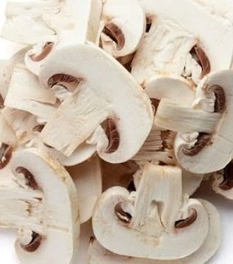 Sliced white mushrooms with visible gills, showcasing a fresh and crisp appearance.