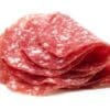 Thinly sliced salami with a marbled pattern of red meat and white fat.