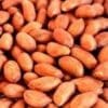 Close-up of unshelled peanuts with reddish-brown shells in a pile.
