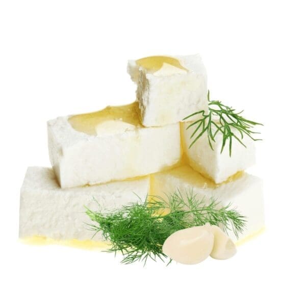 Stack of white cheese cubes with olive oil, fresh dill, and garlic cloves.