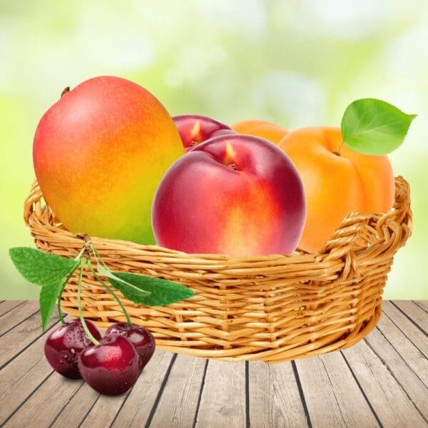 Wicker basket with mango, nectarines, apricots, and cherries on a wooden surface, outdoor setting.