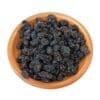 Wooden bowl filled with dried black raisins.