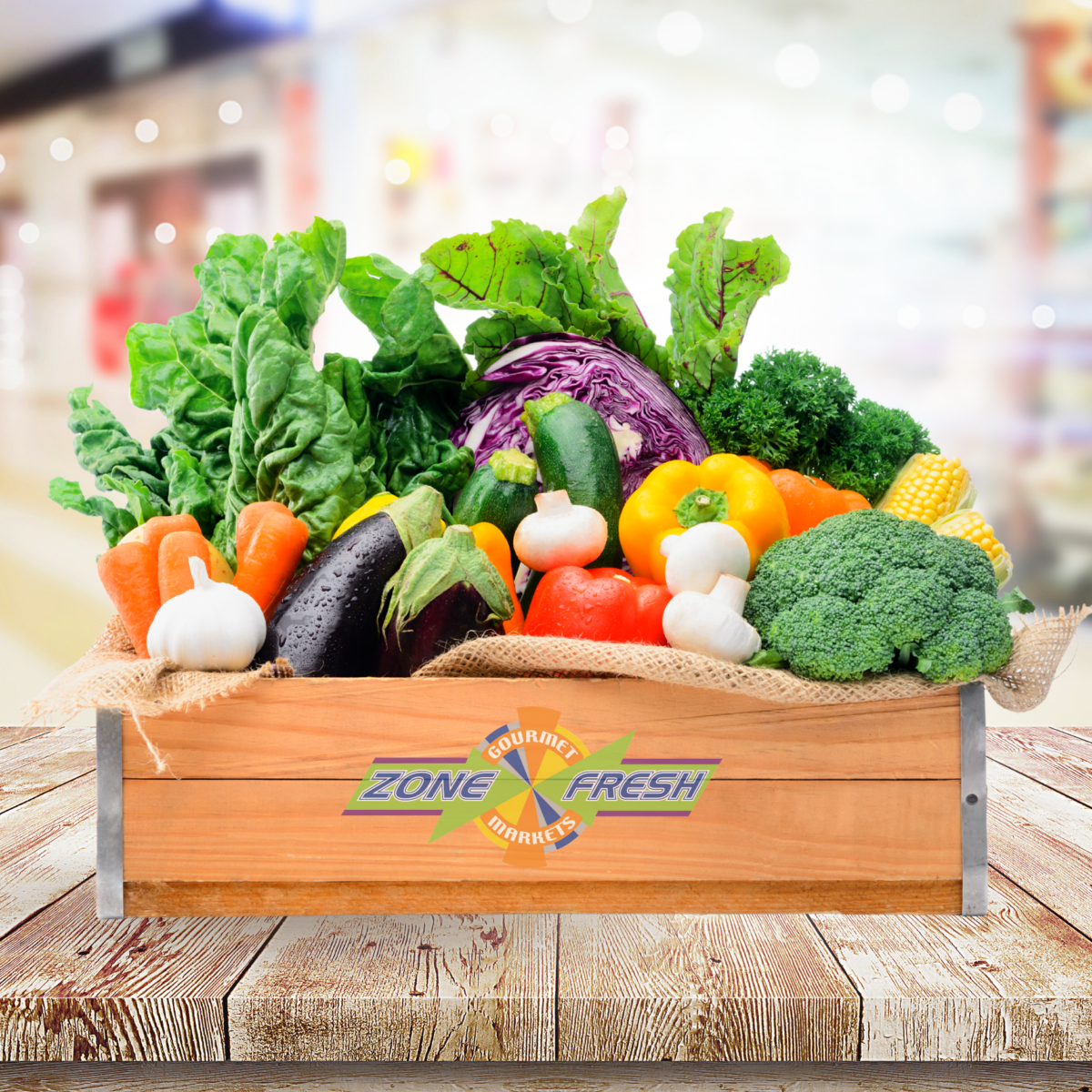 Wooden crate of assorted vegetables with Zone Fresh Gourmet Markets logo on wood surface.